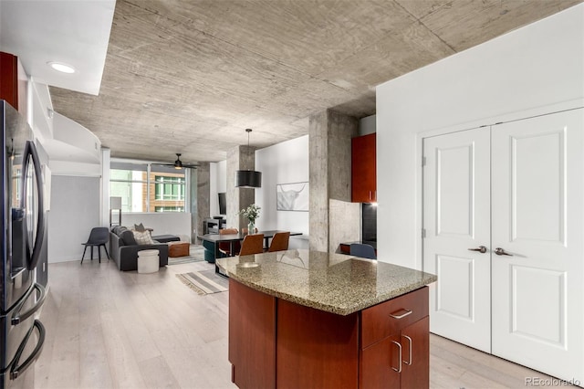 1700 Bassett St Unit 409, Denver, CO 80202 - kitchen with stainless steel fridge, a ceiling fan, open floor plan, light wood-style floors, and a kitchen island