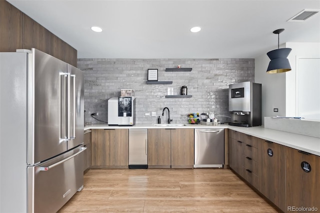 1700 Bassett St Unit 409, Denver, CO 80202 - kitchen with appliances with stainless steel finishes, a sink, light countertops, light wood-type flooring, and recessed lighting