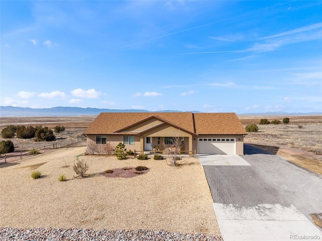 ranch-style house featuring a garage and a mountain view