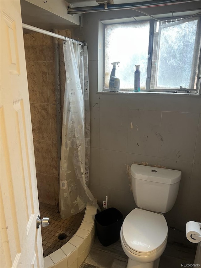 188 S Dale Ct, Denver, CO 80219 - full bathroom featuring a shower stall, toilet, and tile walls
