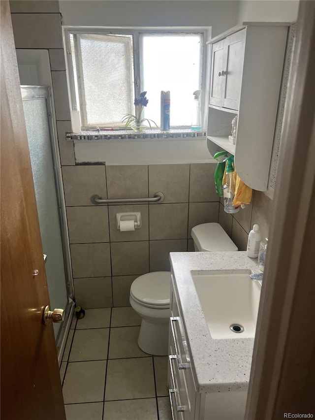 188 S Dale Ct, Denver, CO 80219 - bathroom with a shower stall, tile patterned floors, toilet, vanity, and tile walls