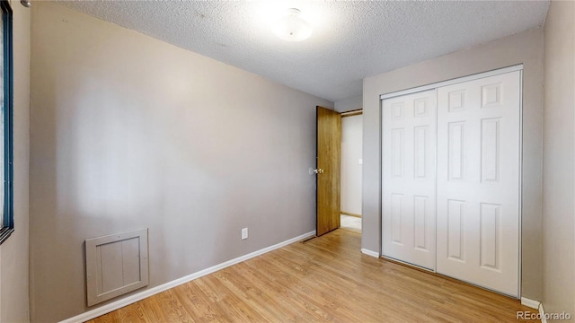 8509 Colorado Ct, Denver, CO 80229 - unfurnished bedroom with light wood finished floors, a textured ceiling, a closet, and baseboards