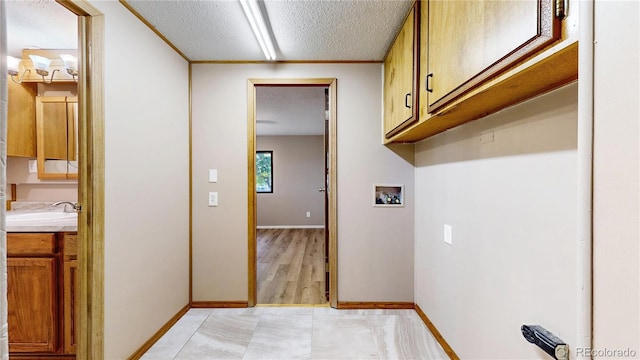 8509 Colorado Ct, Denver, CO 80229 - washroom featuring hookup for a washing machine, cabinet space, a textured ceiling, and baseboards