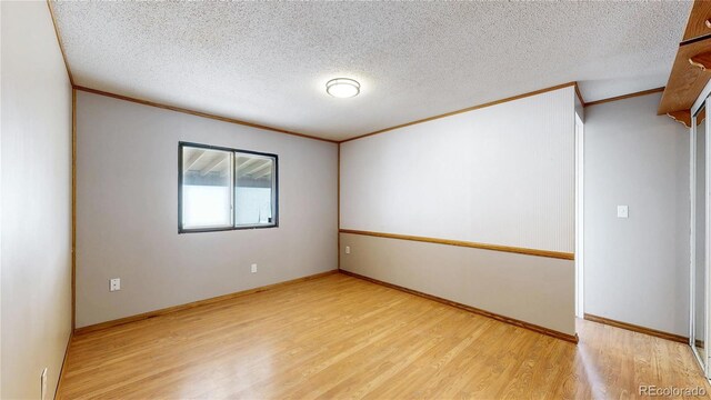 8509 Colorado Ct, Denver, CO 80229 - empty room with crown molding, wood finished floors, a textured ceiling, and baseboards