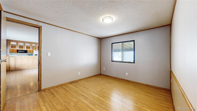 8509 Colorado Ct, Denver, CO 80229 - spare room with crown molding, light wood finished floors, a textured ceiling, and baseboards