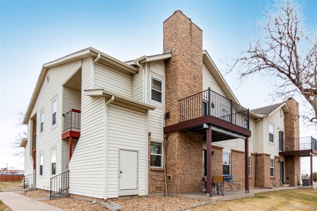 back of property with a balcony and a patio