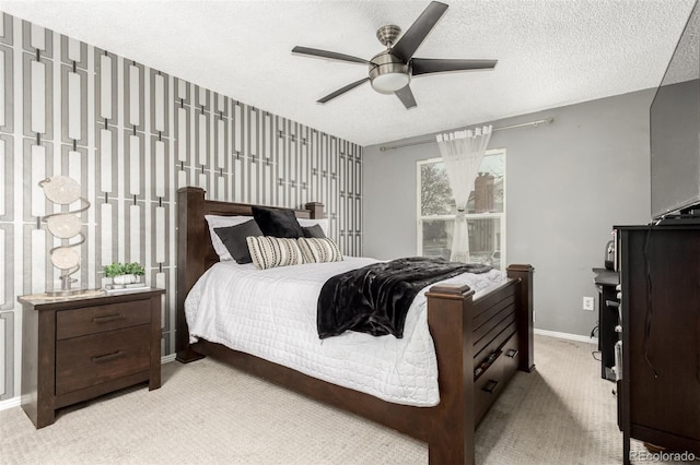 bedroom featuring light carpet, a textured ceiling, and ceiling fan