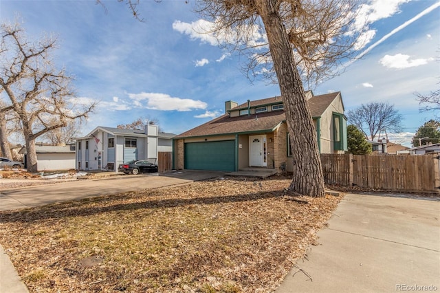 view of front of property with a garage, driveway, and fence