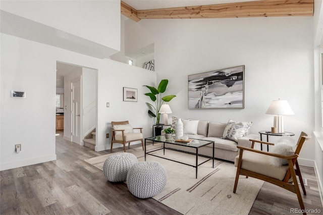 living area featuring stairs, high vaulted ceiling, beamed ceiling, and wood finished floors