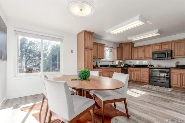 dining space featuring light wood-style floors and baseboards