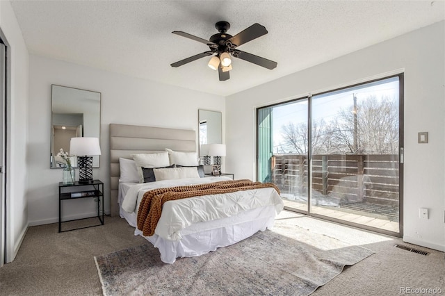 carpeted bedroom featuring a textured ceiling, ceiling fan, visible vents, baseboards, and access to exterior