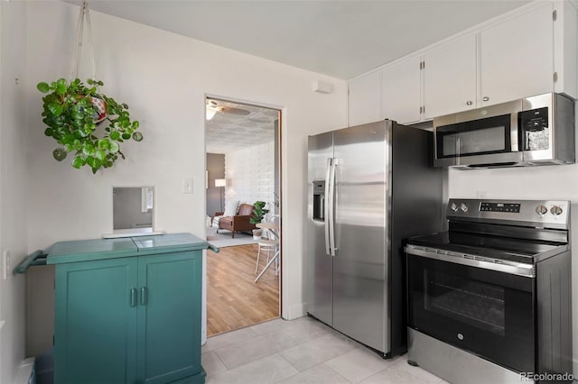 1638 N Foote Ave, Colorado Springs, CO 80909 - kitchen with ceiling fan, white cabinetry, stainless steel appliances, and light tile patterned floors