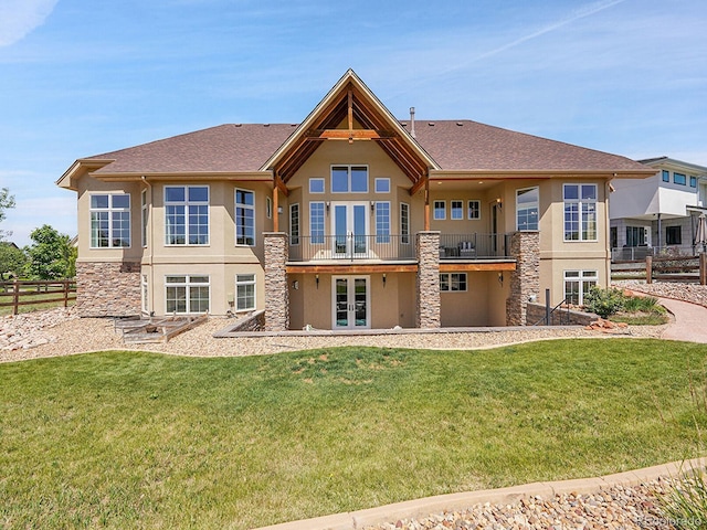 2131 Driver Ln, Erie, CO 80516 - back of property featuring french doors, stucco siding, stone siding, a balcony, and roof with shingles