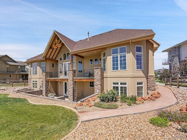 2131 Driver Ln, Erie, CO 80516 - rear view of property featuring stucco siding, a balcony, stone siding, and roof with shingles