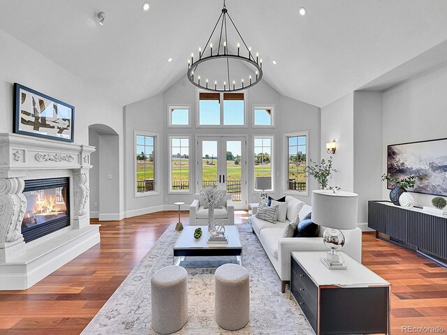 2131 Driver Ln, Erie, CO 80516 - living room with high vaulted ceiling, arched walkways, plenty of natural light, a glass covered fireplace, and wood finished floors