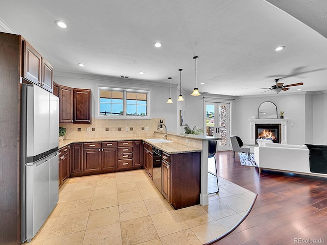 2131 Driver Ln, Erie, CO 80516 - kitchen with freestanding refrigerator, a kitchen bar, a peninsula, recessed lighting, and a ceiling fan