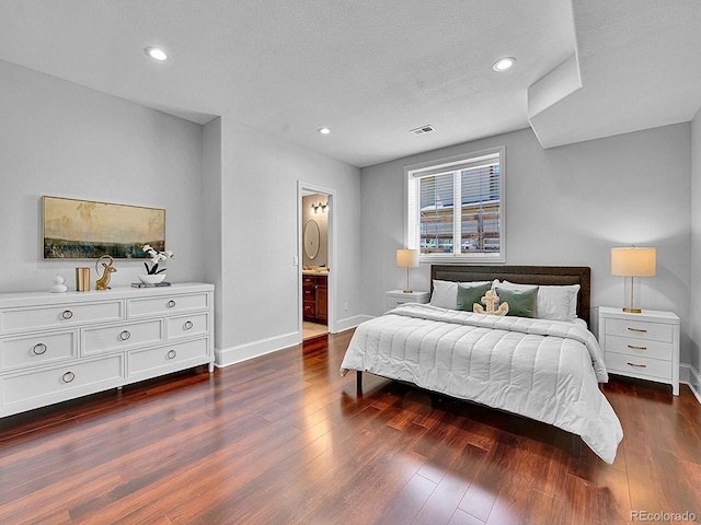 2131 Driver Ln, Erie, CO 80516 - bedroom with dark wood finished floors, recessed lighting, and connected bathroom