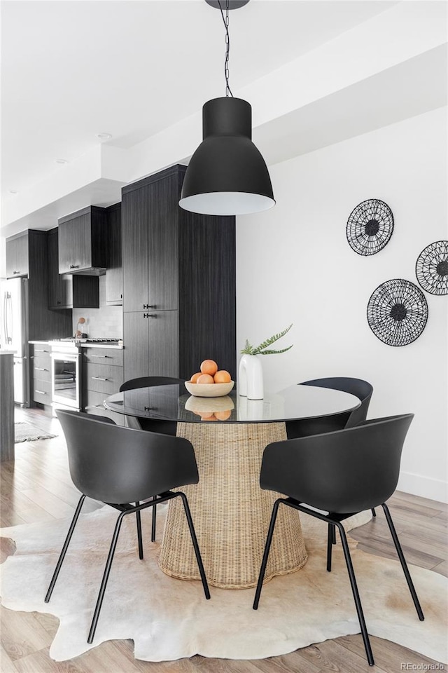 dining room featuring beverage cooler and light wood-type flooring