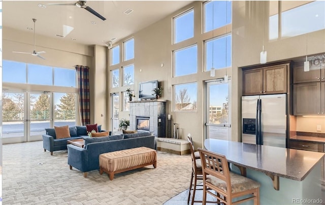 10184 Park Meadows Dr Unit 1317, Lone Tree, CO 80124 - living room with a ceiling fan, a towering ceiling, a fireplace, and light colored carpet