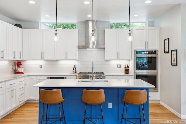 4220 Quitman St, Denver, CO 80212 - kitchen with wall chimney range hood, double oven, backsplash, light countertops, and a kitchen breakfast bar