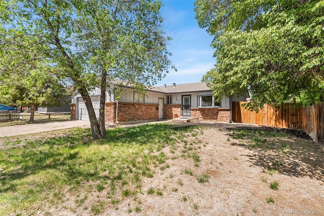 12829 E Nevada Ave, Aurora, CO 80012 - single story home with brick siding, fence, concrete driveway, board and batten siding, and a garage