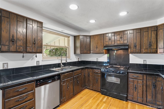 12829 E Nevada Ave, Aurora, CO 80012 - kitchen featuring gas stove, stainless steel dishwasher, a sink, under cabinet range hood, and dark brown cabinets