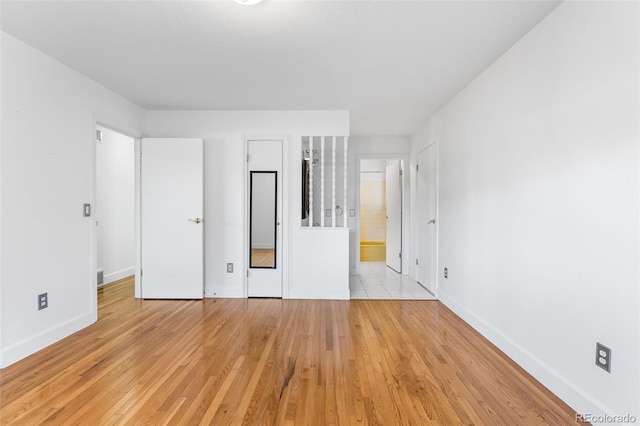 12829 E Nevada Ave, Aurora, CO 80012 - unfurnished bedroom with baseboards, light wood finished floors, and ensuite bathroom