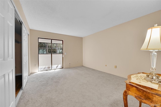 carpeted empty room featuring a textured ceiling