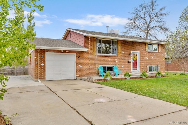 4544 W 65th Ave, Arvada, CO 80003 - bi-level home with fence, brick siding, concrete driveway, a garage, and a front lawn