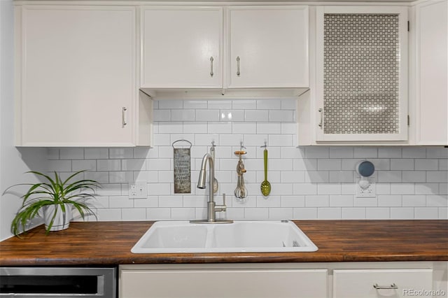 4544 W 65th Ave, Arvada, CO 80003 - kitchen featuring wood counters, white cabinetry, and a sink