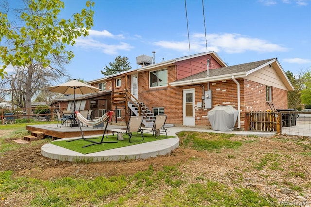 4544 W 65th Ave, Arvada, CO 80003 - rear view of house featuring fence, a patio, brick siding, and a lawn