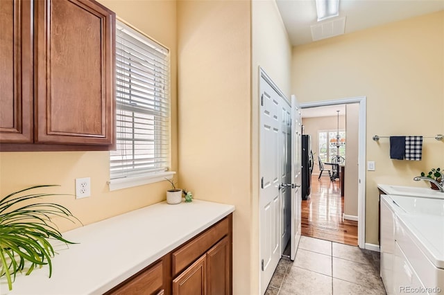 16550 Antero Cir, Broomfield, CO 80023 - laundry area featuring cabinet space, washing machine and dryer, light tile patterned floors, and baseboards