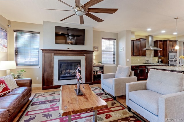 13713 Raritan Ln, Broomfield, CO 80023 - living room featuring a ceiling fan, a glass covered fireplace, recessed lighting, and light wood finished floors