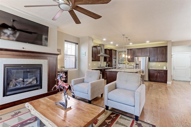 13713 Raritan Ln, Broomfield, CO 80023 - living area with light wood-style floors, a ceiling fan, a brick fireplace, and recessed lighting