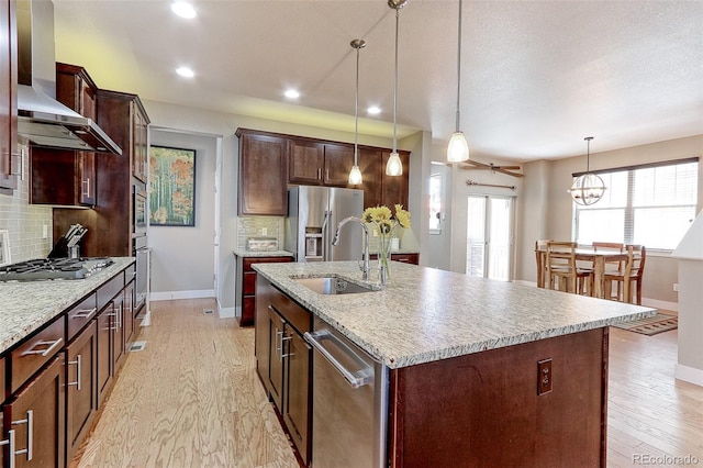 13713 Raritan Ln, Broomfield, CO 80023 - kitchen featuring wall chimney exhaust hood, stainless steel appliances, light wood-type flooring, decorative backsplash, and recessed lighting