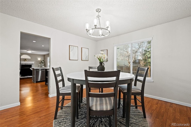 dining room featuring dark hardwood / wood-style flooring, a chandelier, and a textured ceiling