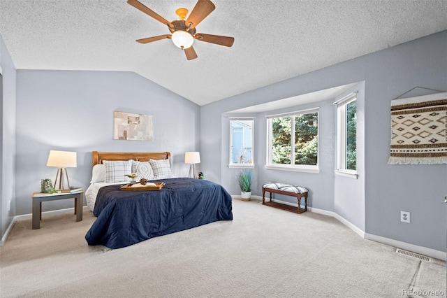 bedroom with a textured ceiling, ceiling fan, carpet, and vaulted ceiling