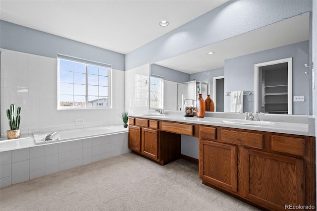 bathroom featuring vanity and a relaxing tiled tub