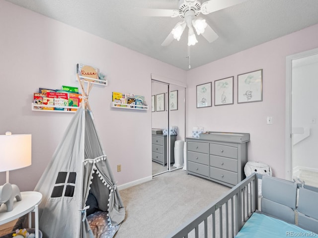 bedroom featuring light carpet, a textured ceiling, a closet, and ceiling fan