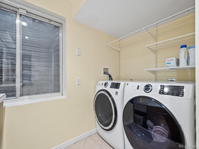 clothes washing area featuring separate washer and dryer and light tile patterned floors