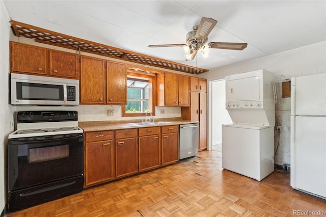 1175 Xanthia, Denver, CO 80220 - kitchen featuring appliances with stainless steel finishes, stacked washer / dryer, brown cabinets, and light countertops