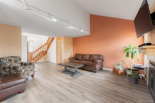 9563 Milwaukee Ct, Thornton, CO 80229 - living area featuring rail lighting, wood finished floors, and stairs