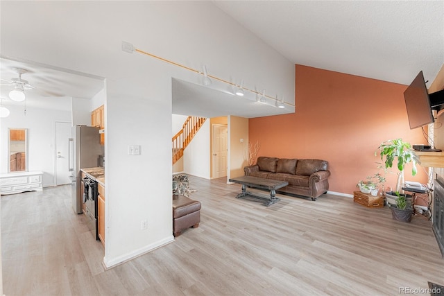 9563 Milwaukee Ct, Thornton, CO 80229 - living area with light wood-type flooring, ceiling fan, stairs, and high vaulted ceiling