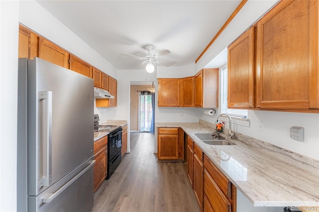 9563 Milwaukee Ct, Thornton, CO 80229 - kitchen featuring freestanding refrigerator, black / electric stove, under cabinet range hood, ceiling fan, and brown cabinets