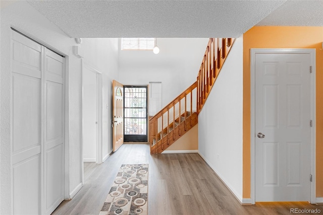9563 Milwaukee Ct, Thornton, CO 80229 - entryway featuring light wood-type flooring, stairs, and a textured ceiling