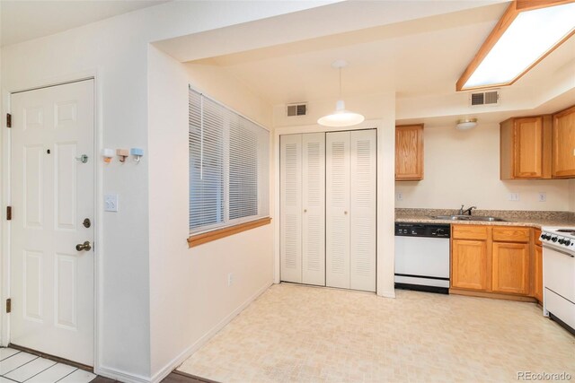 kitchen featuring white appliances, sink, hanging light fixtures, and light tile patterned floors