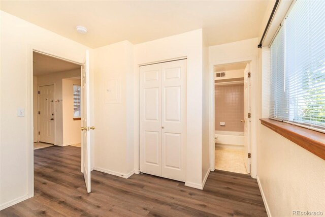 unfurnished bedroom featuring dark hardwood / wood-style flooring and a closet