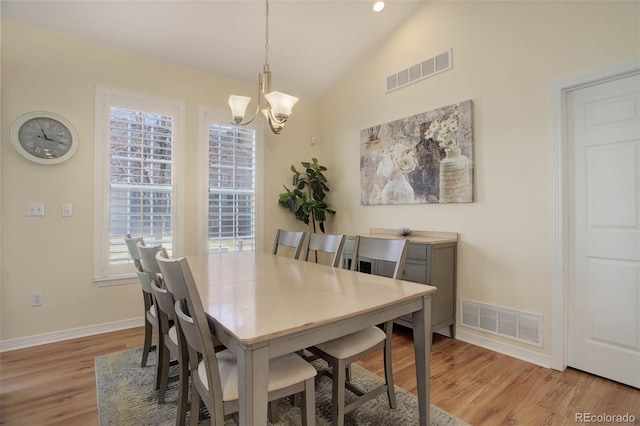 dining room featuring lofted ceiling, a chandelier, visible vents, and light wood-style floors