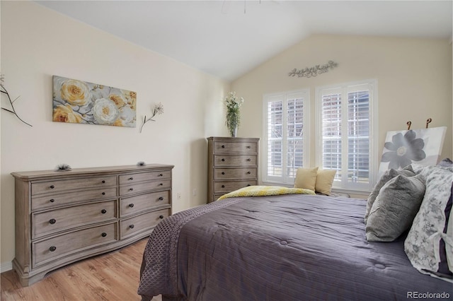 bedroom with lofted ceiling and light wood-style flooring