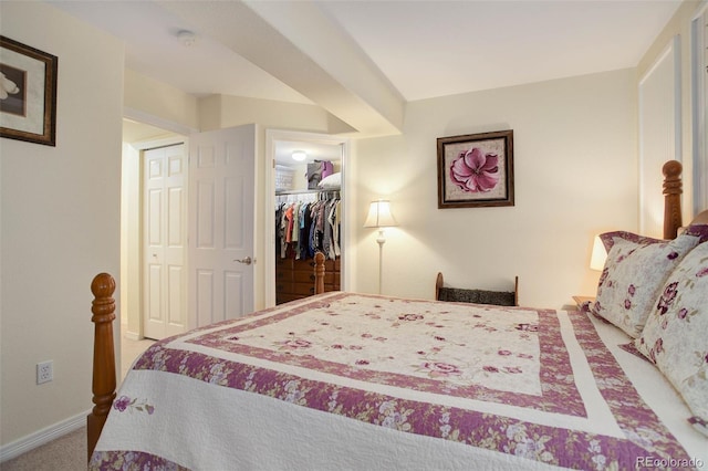 bedroom featuring carpet floors, baseboards, a walk in closet, and a closet